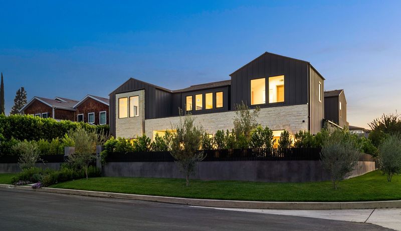 A large house with a lot of windows is lit up at night.