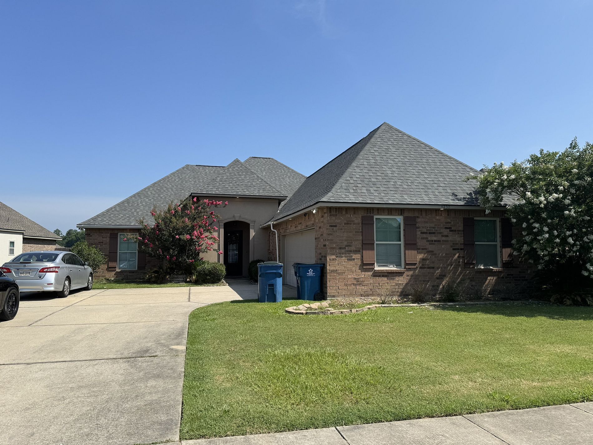 A brick house with a car parked in front of it.