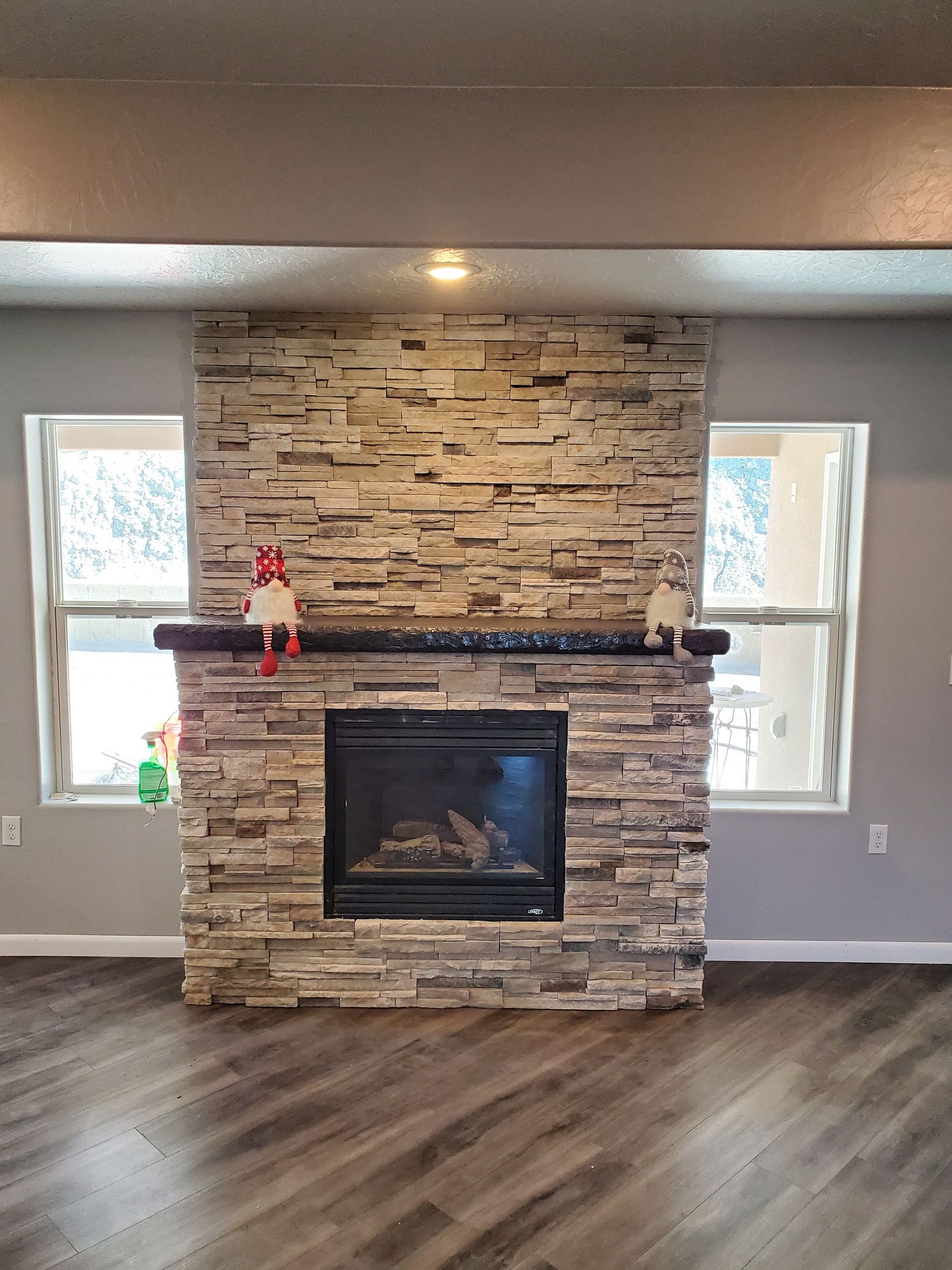 Construction worker on ladder, installing electrical and plumbing in a room under construction.