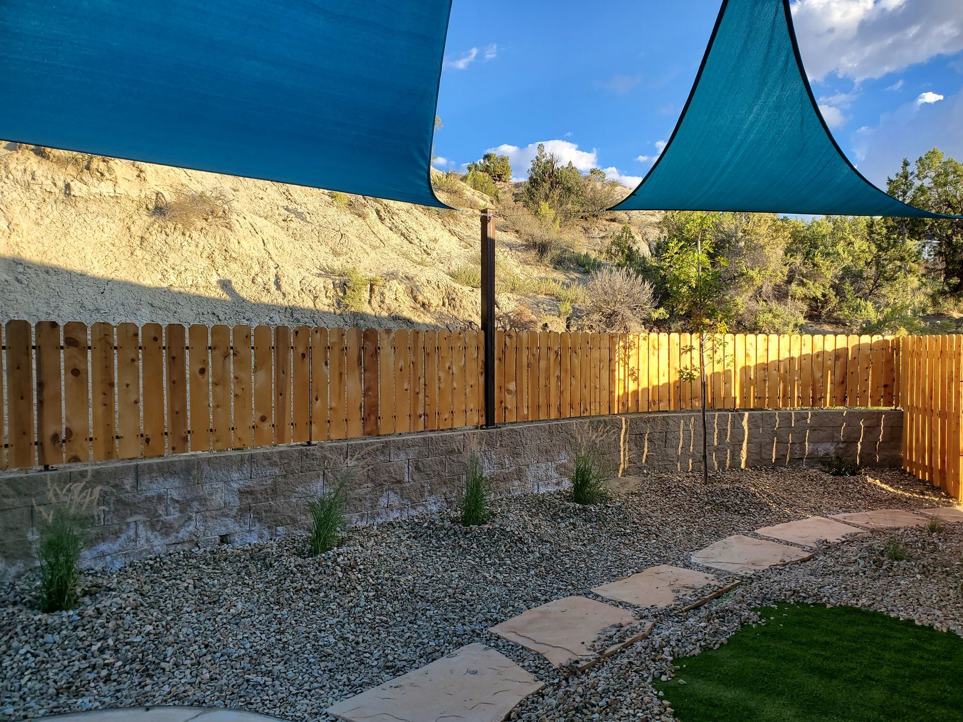 Architects reviewing blueprints on a table with a building model, hard hats, and tools.