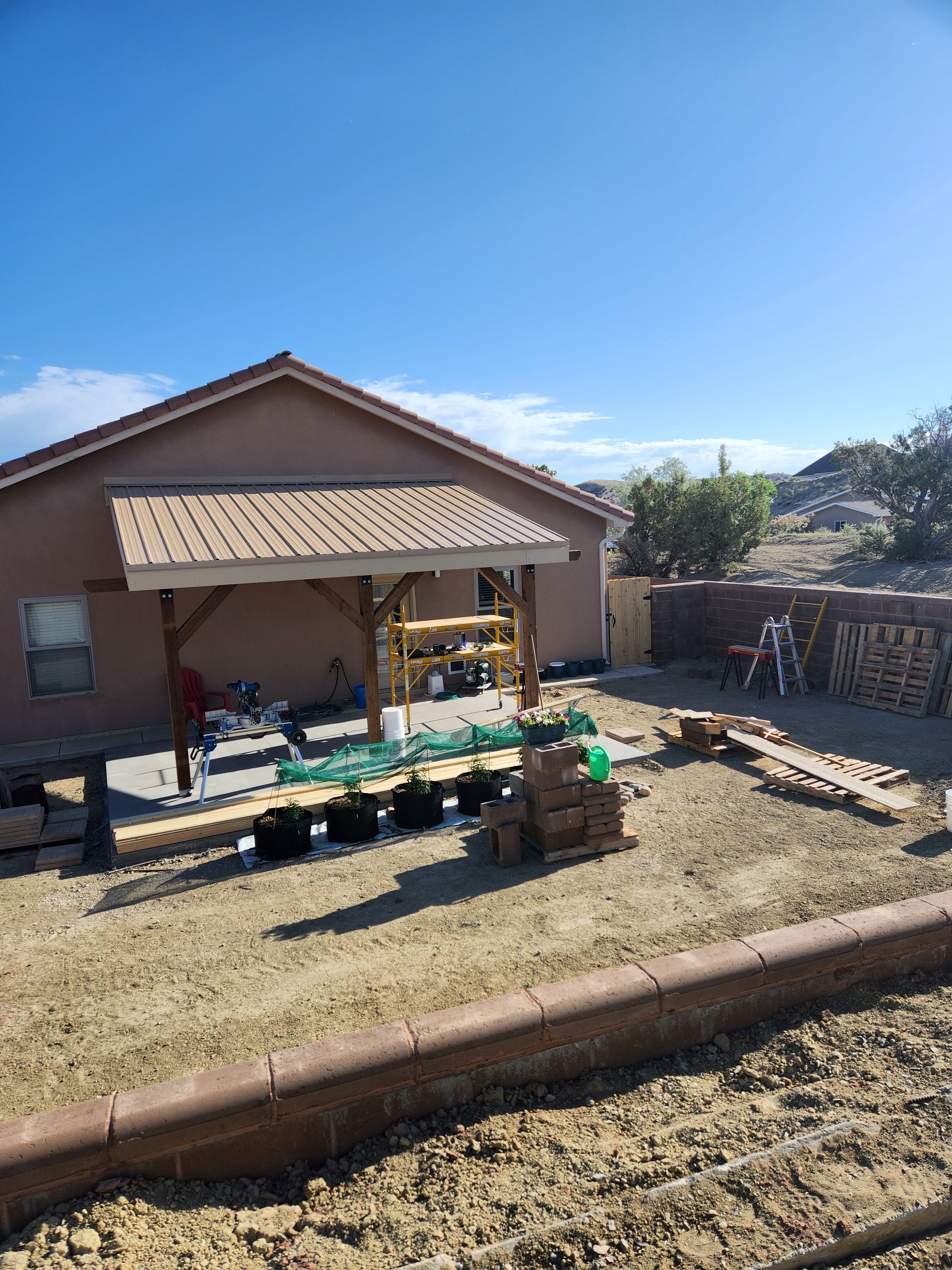 A repairman and a woman in a kitchen review paperwork. The repairman smiles, holding a clipboard.