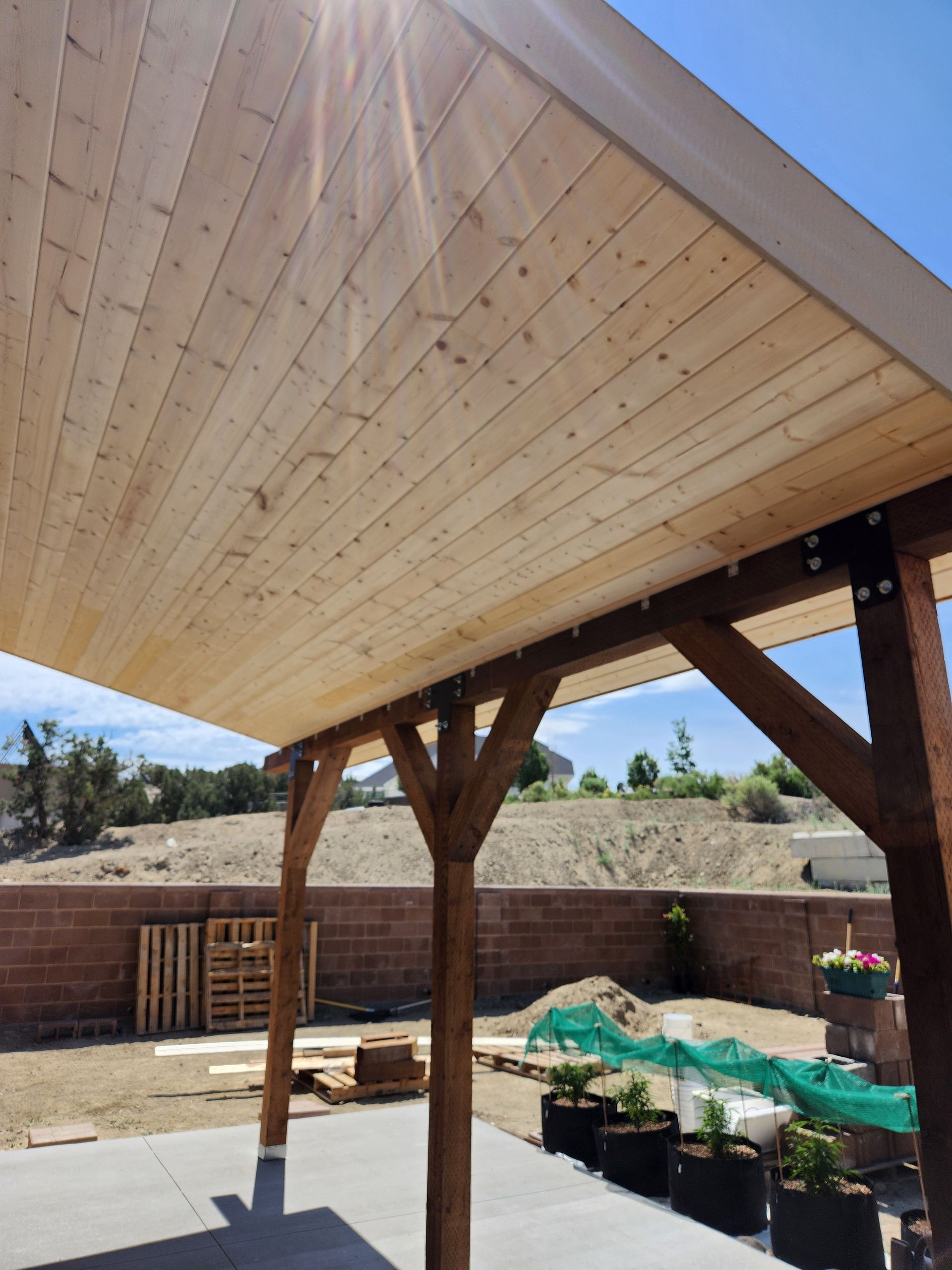 Hammer lying on a light gray tiled floor with long shadows cast by sunlight.