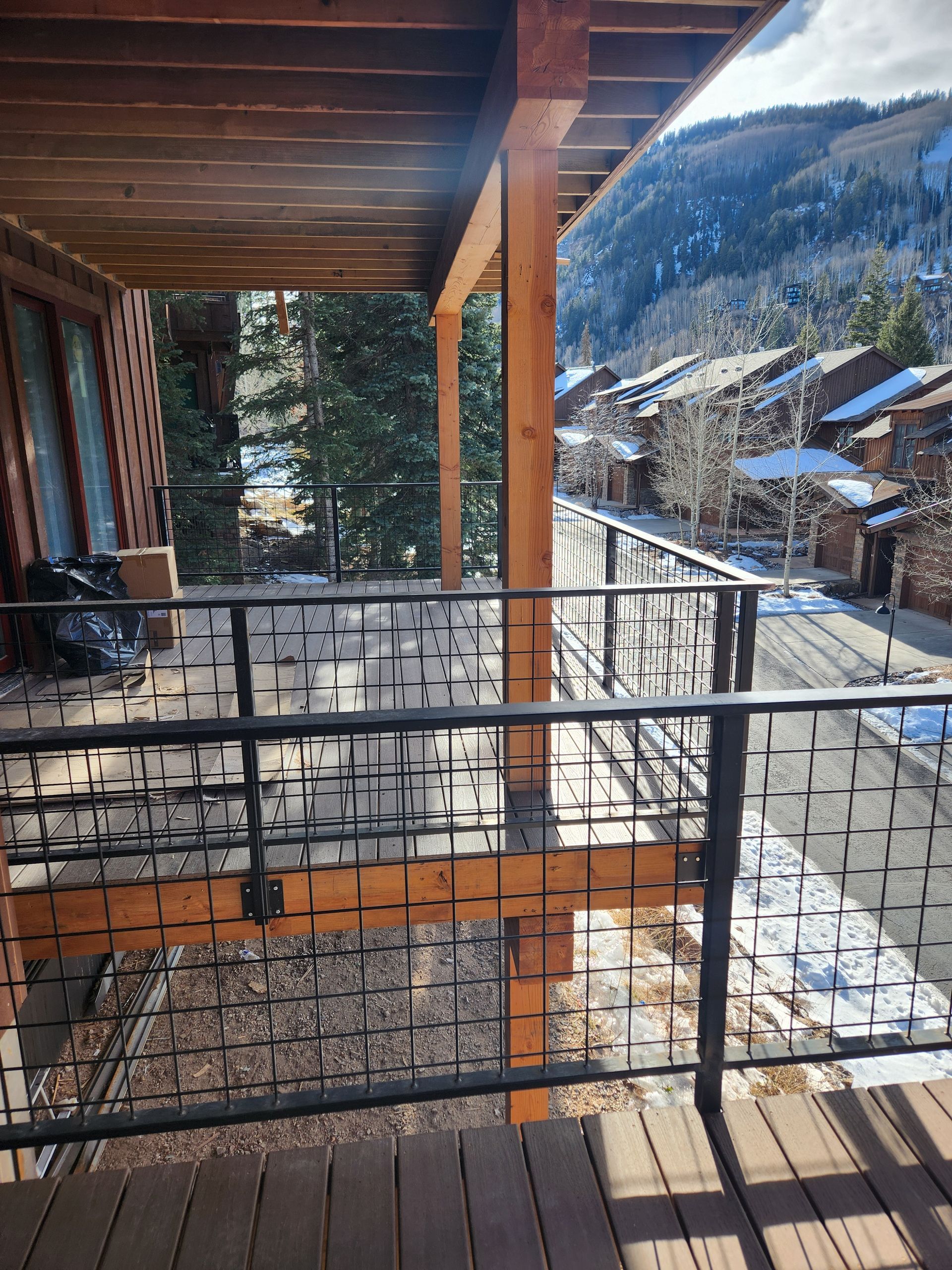 Electrician in an orange jumpsuit working on an electrical outlet on a white wall.