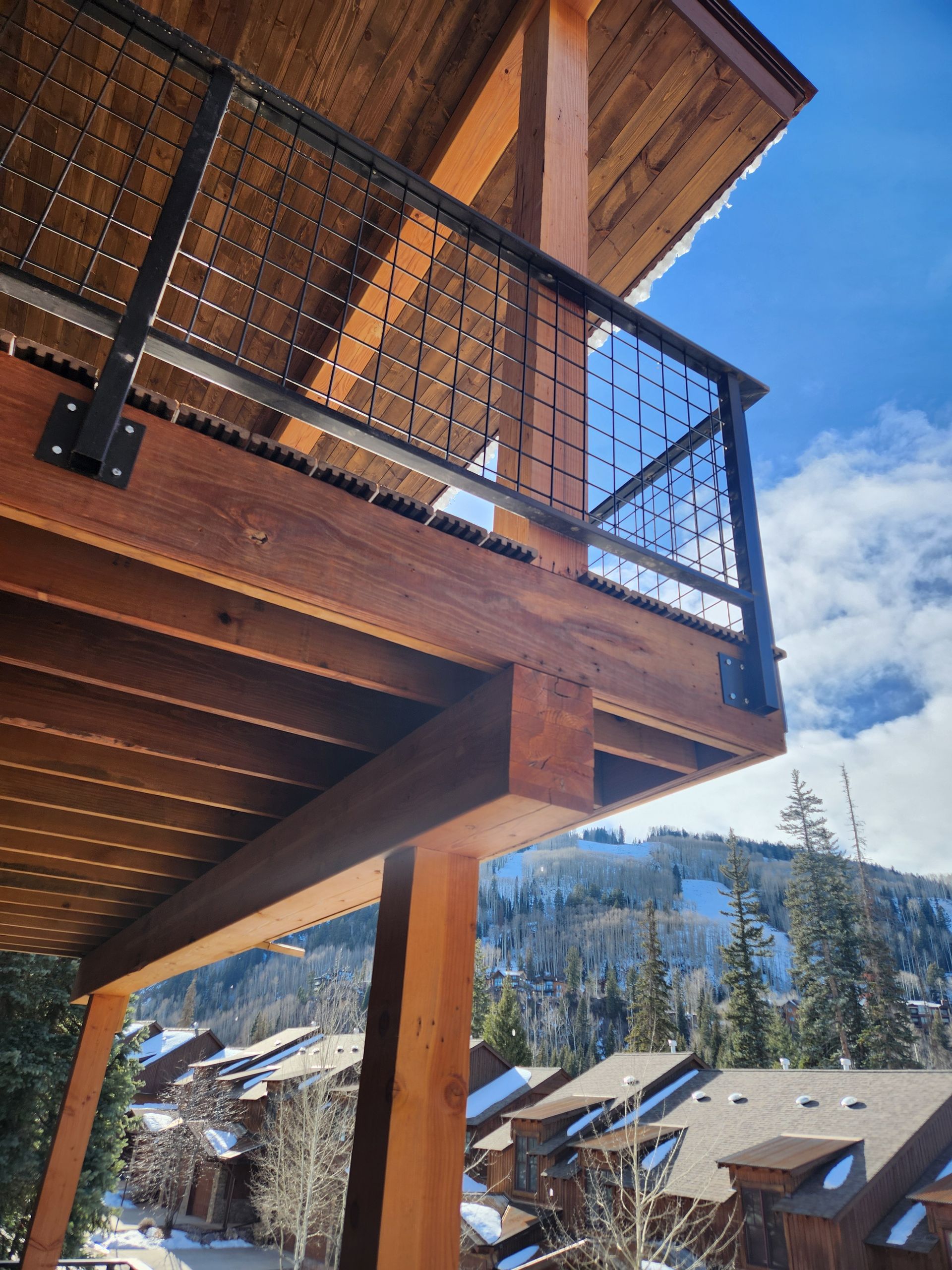 People in safety vests examining blueprints with miniature house models.