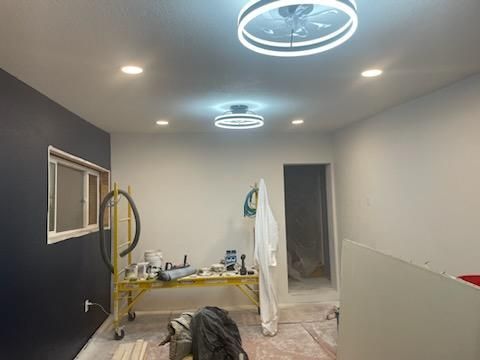 Room under construction with dark blue wall, work table, and ceiling lights.