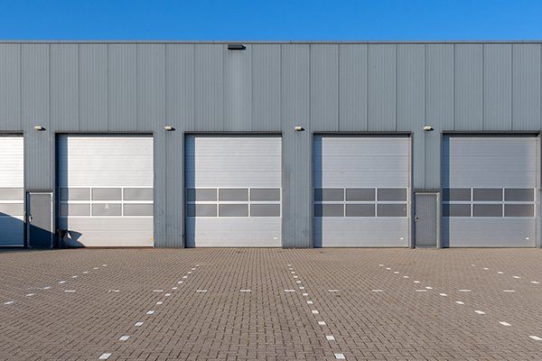 Row of Grey Industrial Units with Roller Shutter Doors — Hasbrouck Heights, NJ — Reiner Overhead Door