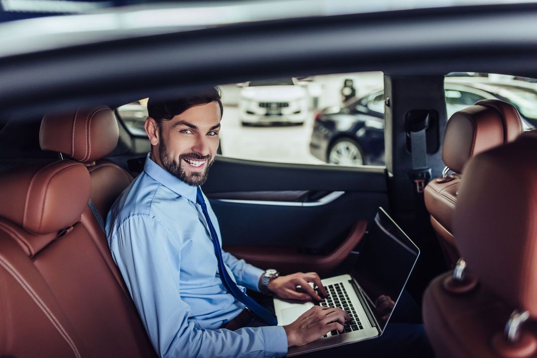 Un gruppo di persone guarda un'auto blu in uno showroom.