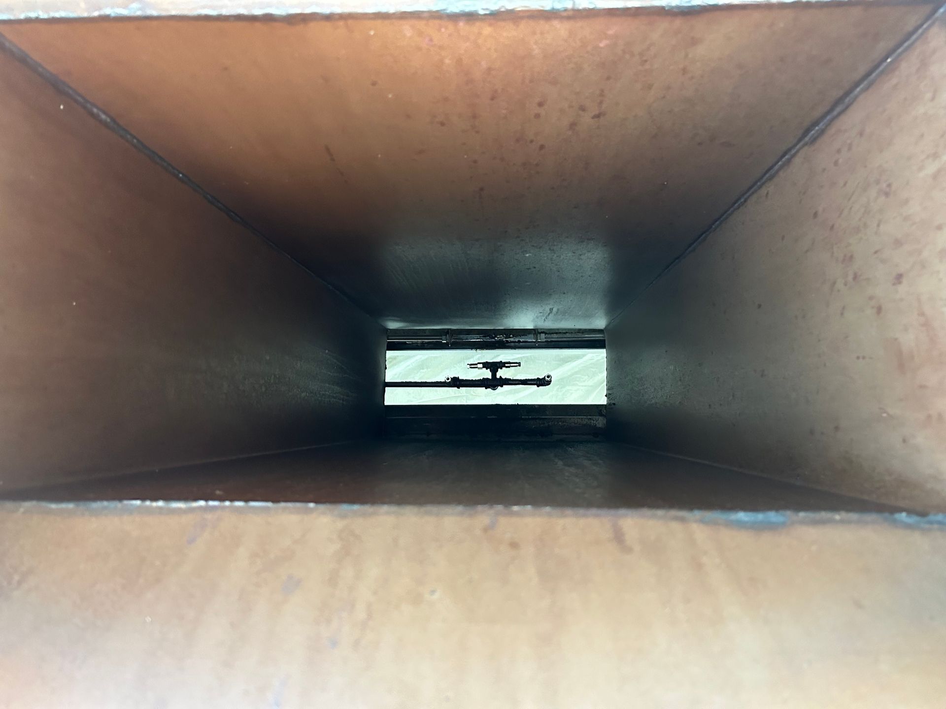 A close up of a hole in a wooden box.