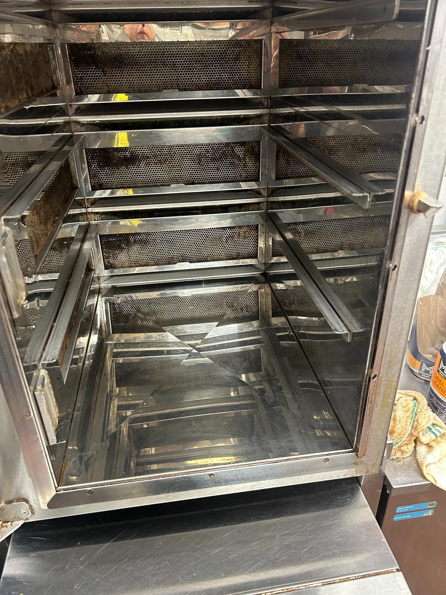 Open, stainless steel oven interior with multiple rack levels.