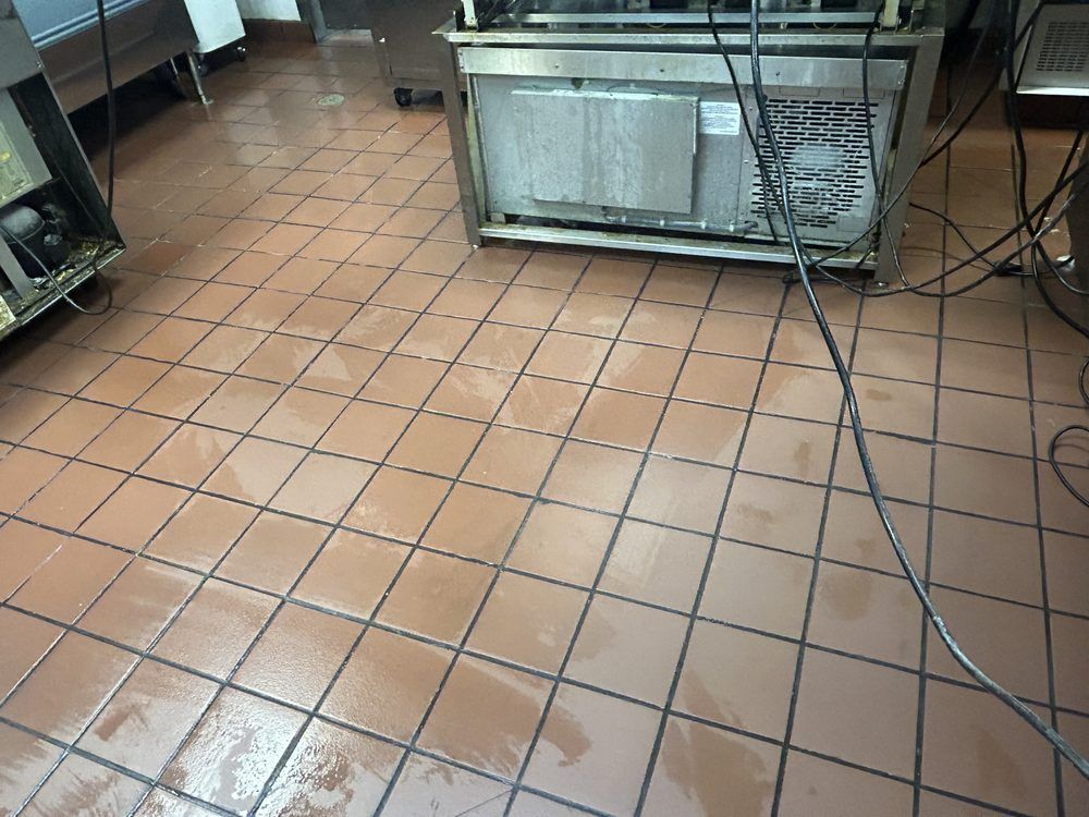 A kitchen with a tiled floor and a stainless steel refrigerator.