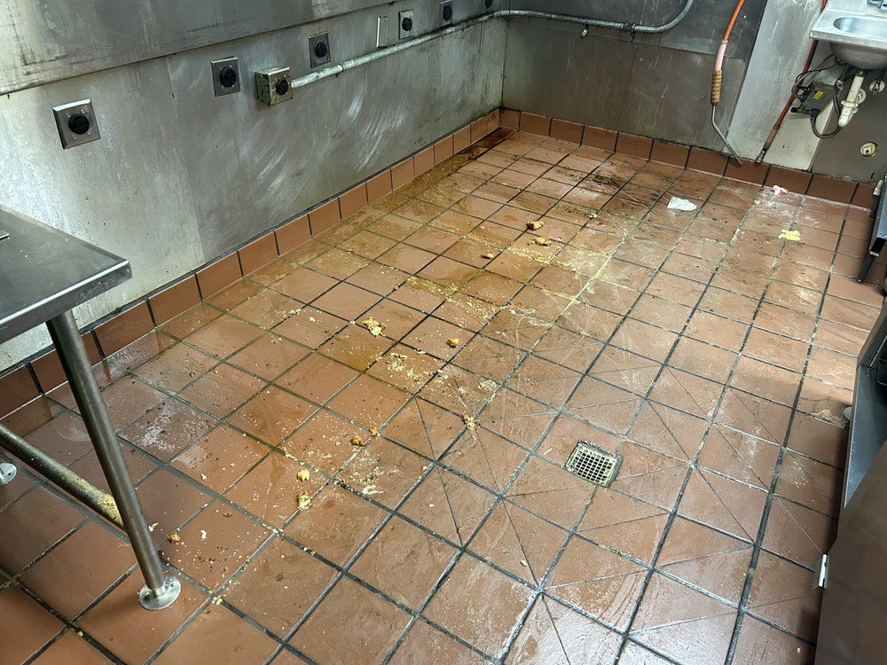A kitchen with dirty tile floors and a sink.