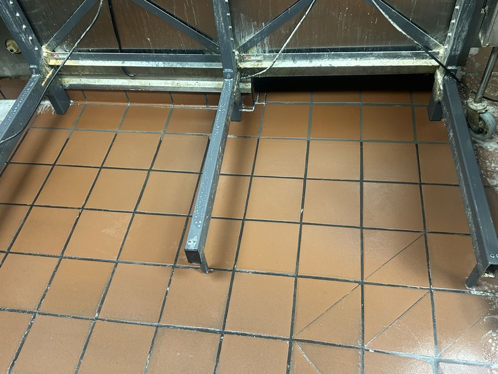 A tiled floor with a metal frame in the background