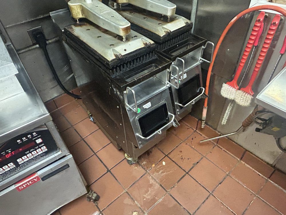 A kitchen with a lot of appliances and a hose.