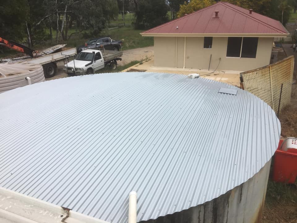 A White Truck Is Parked In Front Of A House With A Metal Roof – Perth, WA - Armadale Concrete Tank Co.