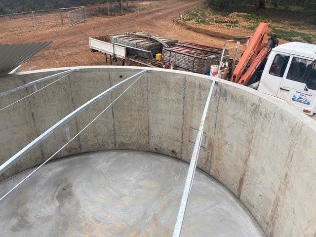 Concrete water tank beside a shed in rural Western Australia
