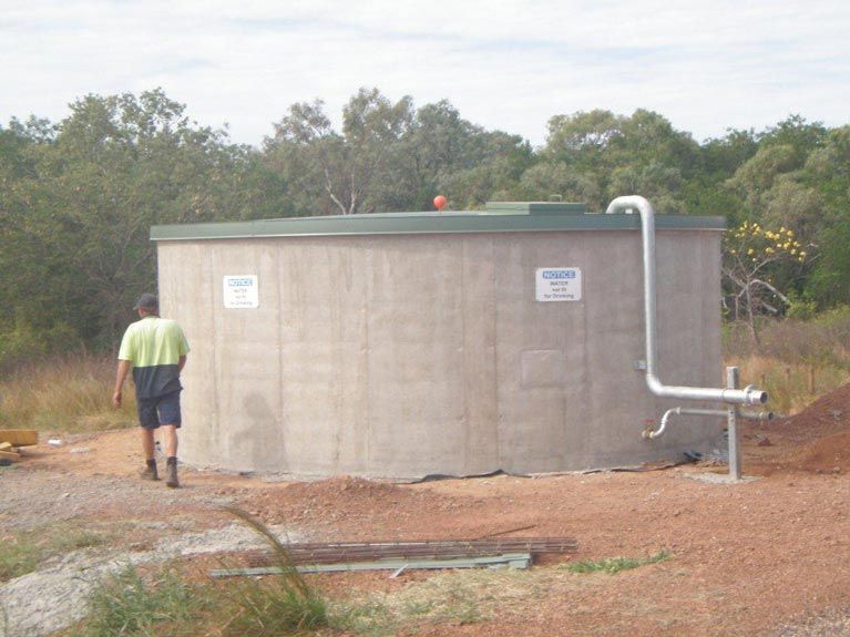 A Man Is Standing In Front Of A Large Concrete Tank – Perth, WA - Armadale Concrete Tank Co.