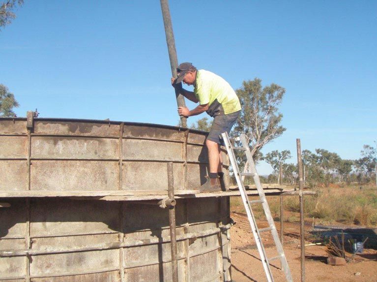 A Man On A Ladder Working On A Concrete Structure – Perth, WA - Armadale Concrete Tank Co.