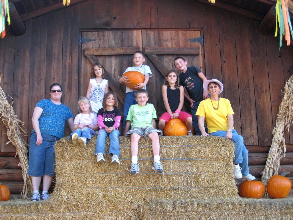 kids sitting on hay bales at the pumpkin patch