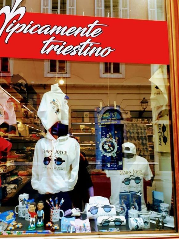 Vetrina con felpe e magliette bianche con occhiali da sole, sopra il cartello