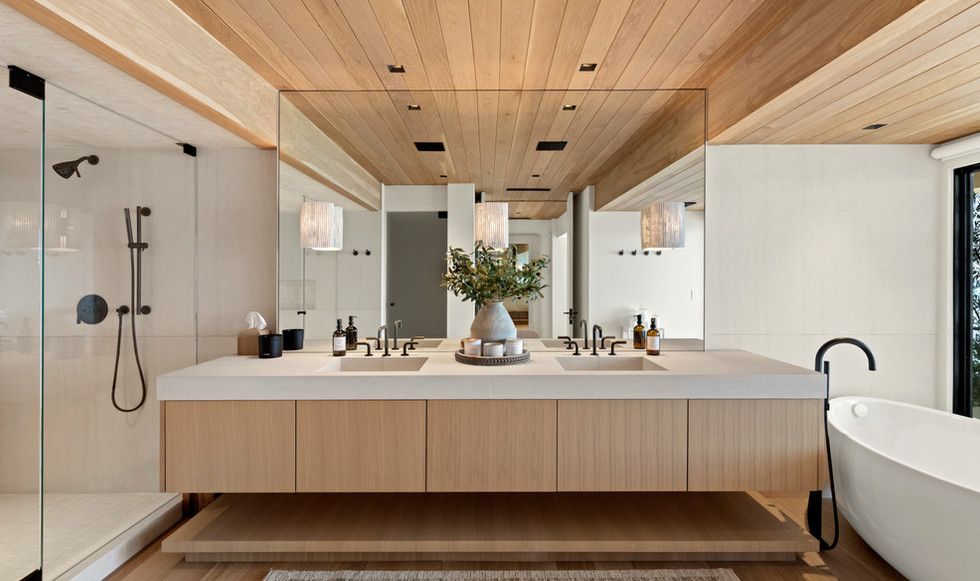 A bathroom with two sinks , a tub and a shower.