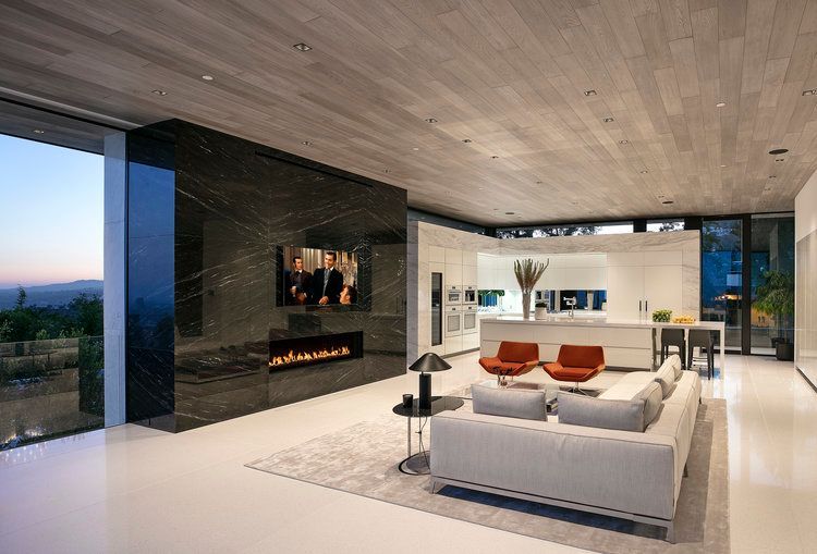 A living room with a couch , fireplace and television.