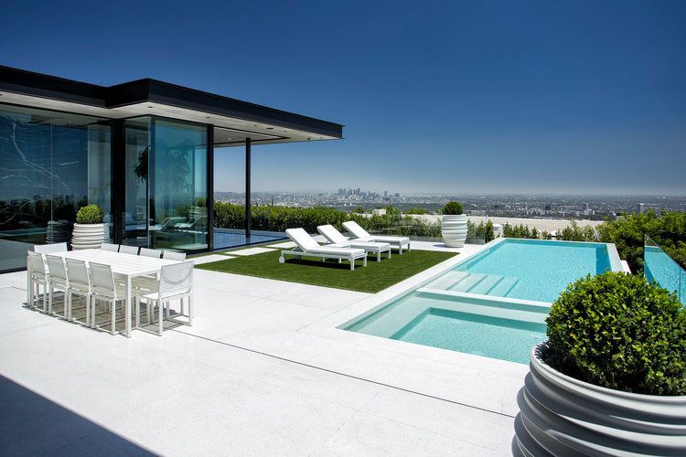 There is a large swimming pool in the backyard of a house.