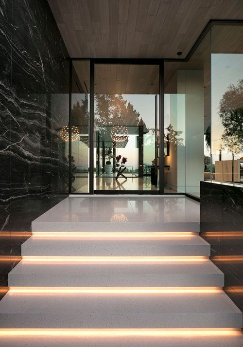 A set of stairs leading up to a glass door in a building.