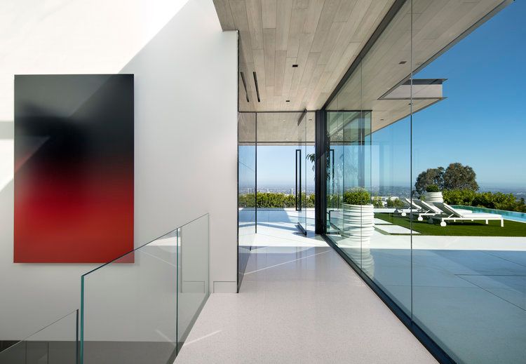 A hallway with a large window and a painting on the wall