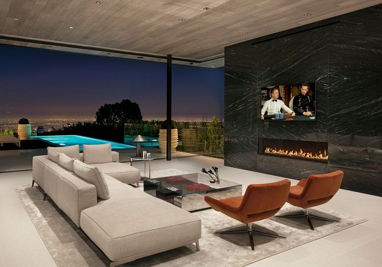 A living room with a couch , chairs , a fireplace and a flat screen tv.