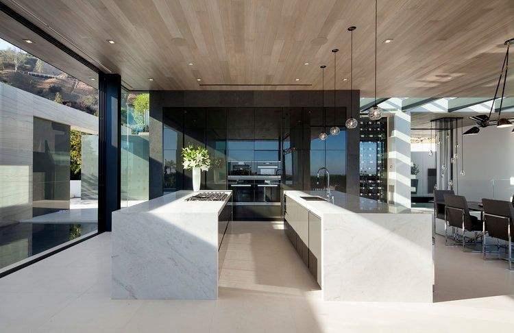 A kitchen with a lot of windows and marble counter tops