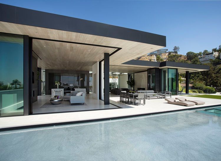 A modern house with a large swimming pool in front of it