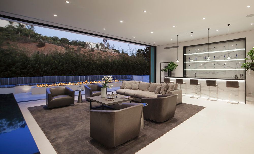 A living room with a couch , chairs , and a bar.