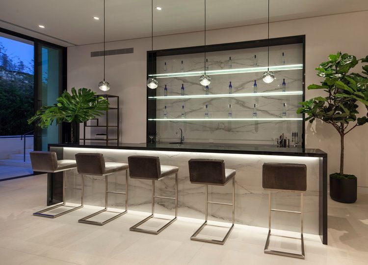 A bar with stools and a marble counter top in a room.