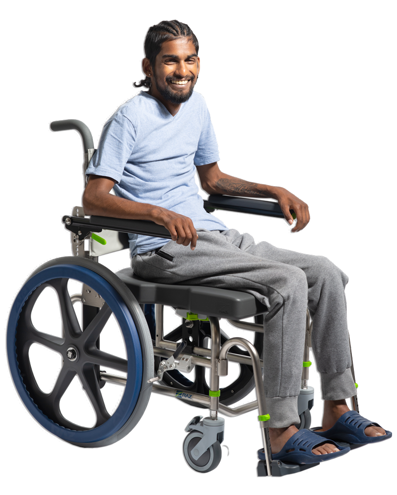 Man in wheelchair smiling, wearing blue shirt and grey sweatpants.