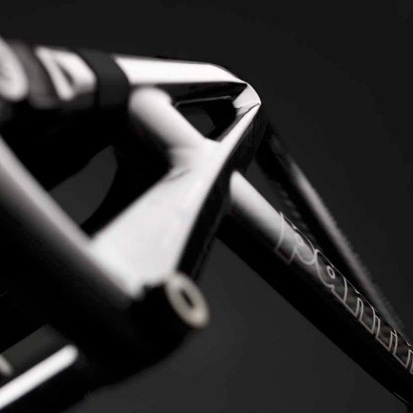 Close-up of a black bicycle frame with white lettering on a dark background.