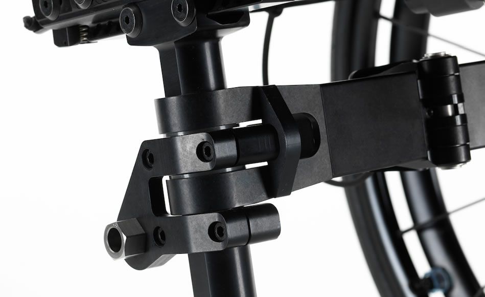 Close-up of black metal wheelchair component, joints and bolts visible, against a white background.