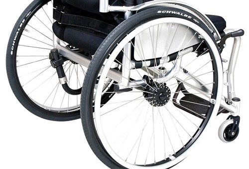 Wheelchair with black tires and white rims, rear view, metal frame.