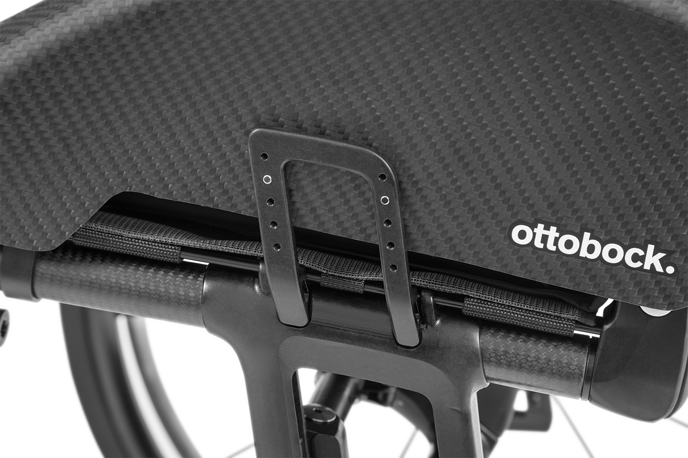 Black and white close-up of an Ottobock wheelchair fender with a carbon fiber finish and a handle.