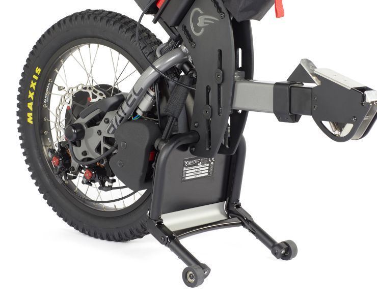 Black electric-powered wheelchair with large rear wheel, disc brakes, and a support stand.