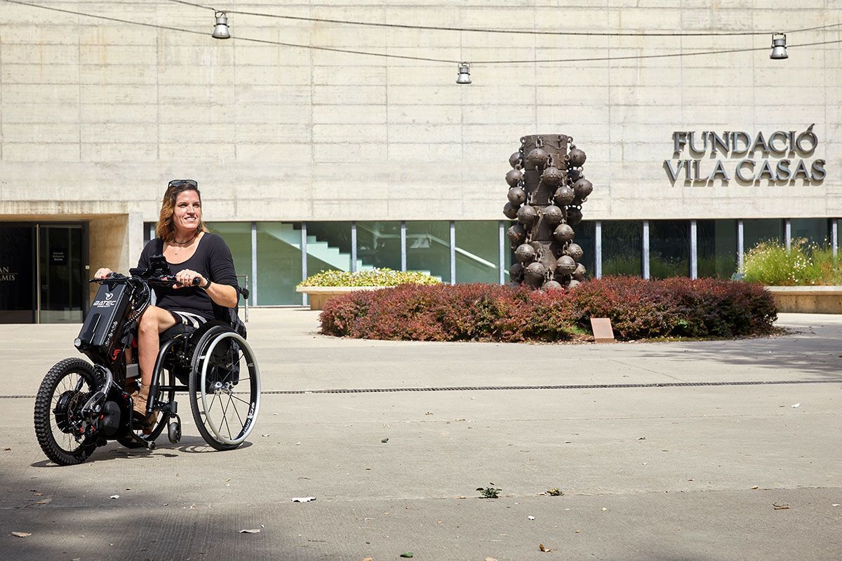 Woman in wheelchair in front of Fundació Vila Casas building.
