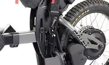 Close-up of a black adaptive bicycle frame and rear wheel, with a trailer hitch, and tire marked