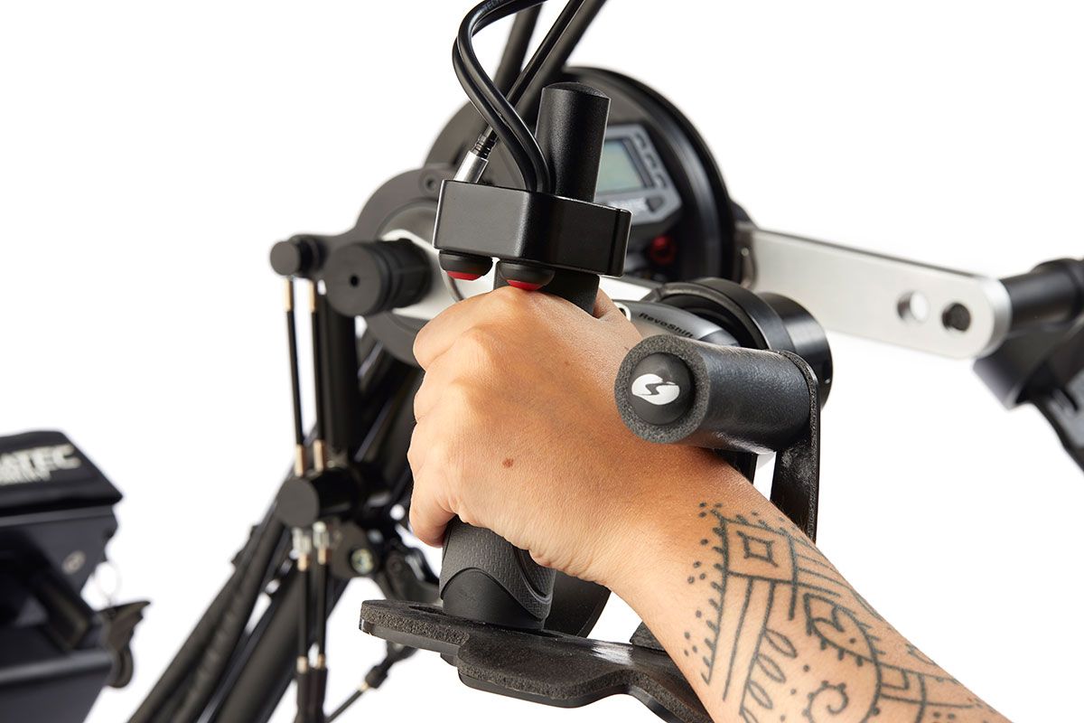Hand gripping the handle of a mobility device, with a tattoo visible.