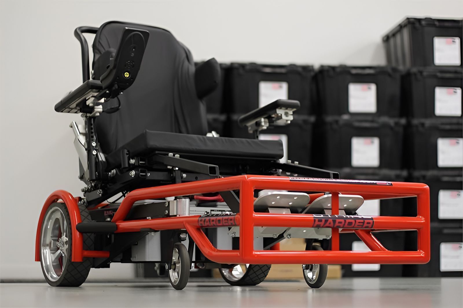Power wheelchair with orange front bumper, indoors.