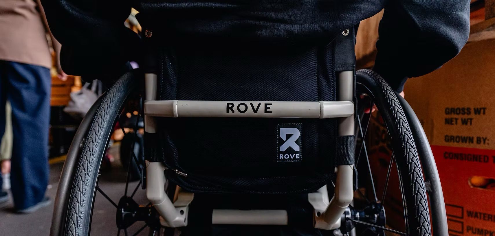 Person in a wheelchair, seen from behind. The word 