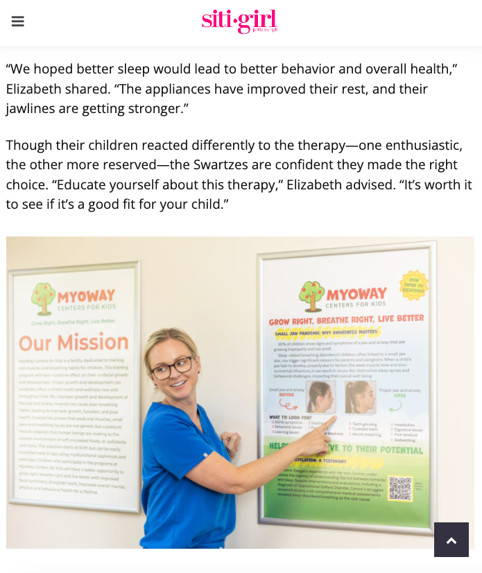 A woman is pointing at a poster on a wall.