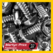 A black and white photo of a pile of nuts and bolts.