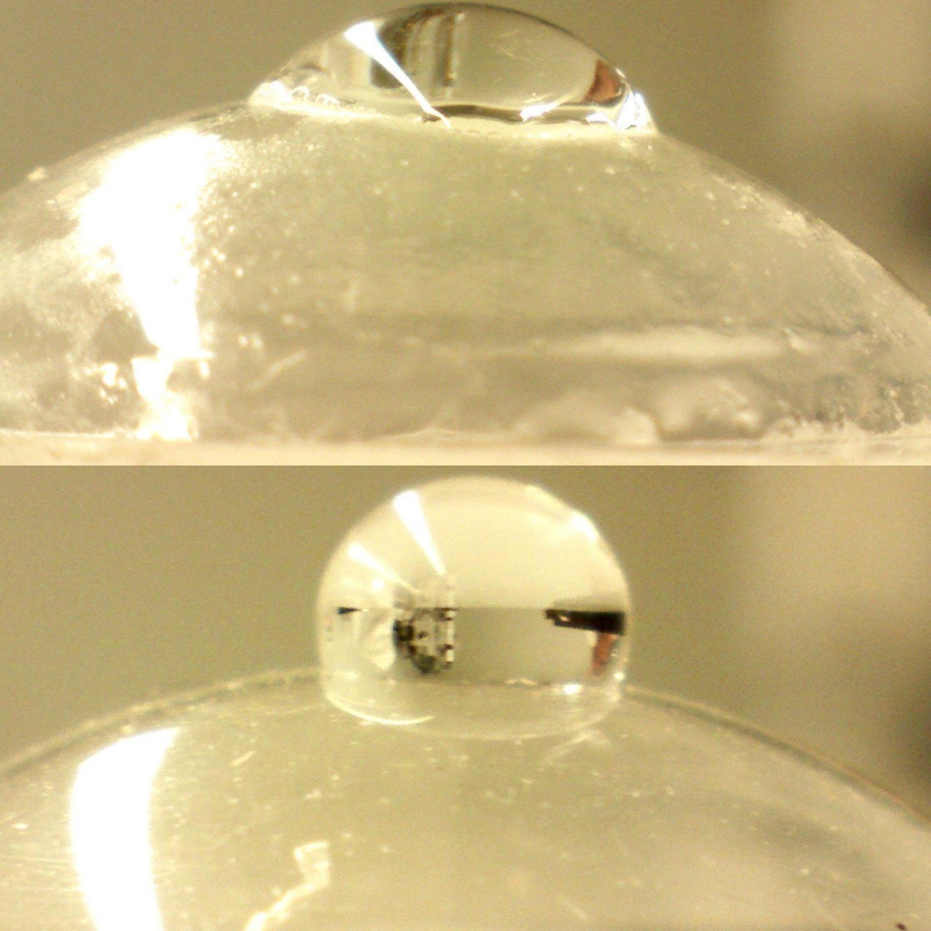 A close up of a bubble with a drop of water on it