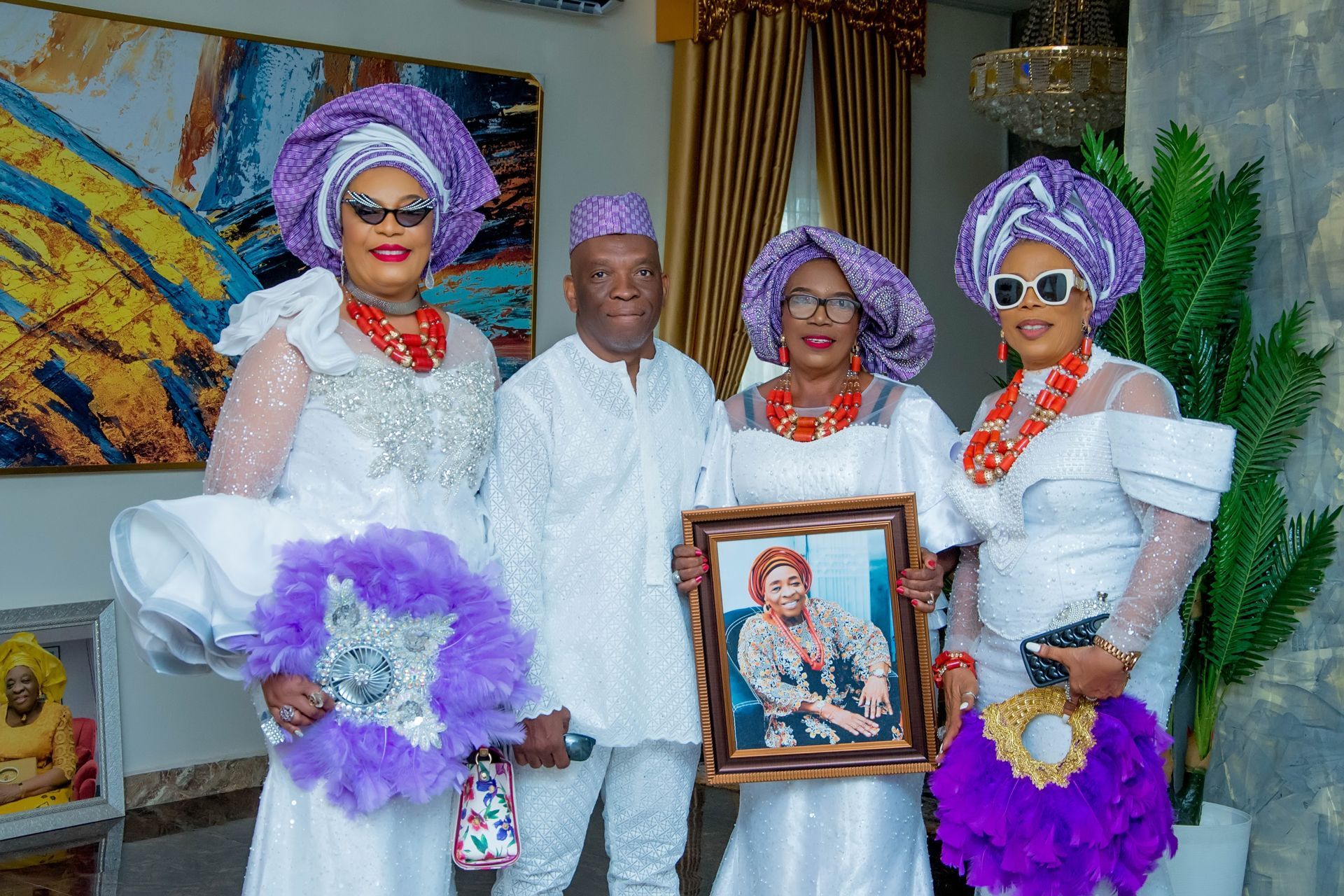 A group of people are standing next to each other in a room holding a picture.