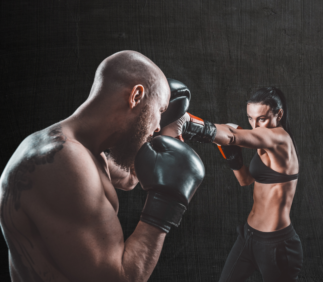 A boy and a girl are standing next to each other in karate uniforms.