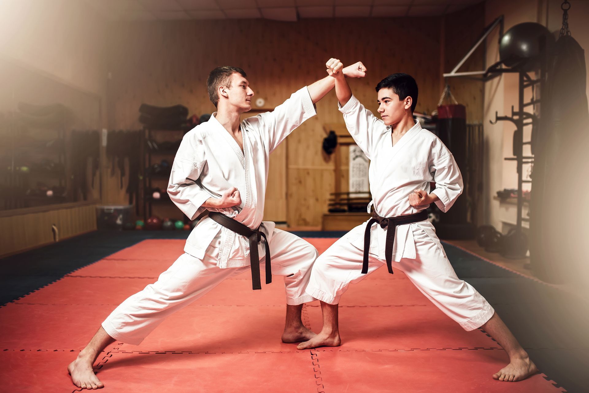Two young men are practicing karate in a gym.